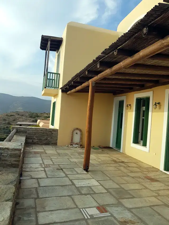 Πρόσοψη κατοικίας σε ζεστή ώχρα με πράσινα κουφώματα